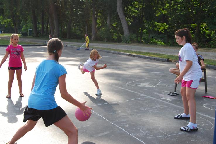 Taylor Martin puts a spin on the ball in foursquare, eliminating Tessa Gardinier from play. Also pictured are Payton Powers (right) and Ashley Gillen (left).